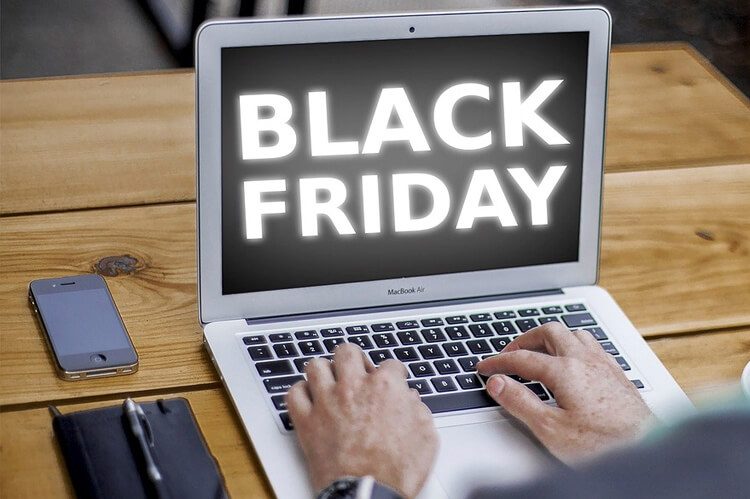 Pessoa utilizando computador com logo da Black Friday na tela